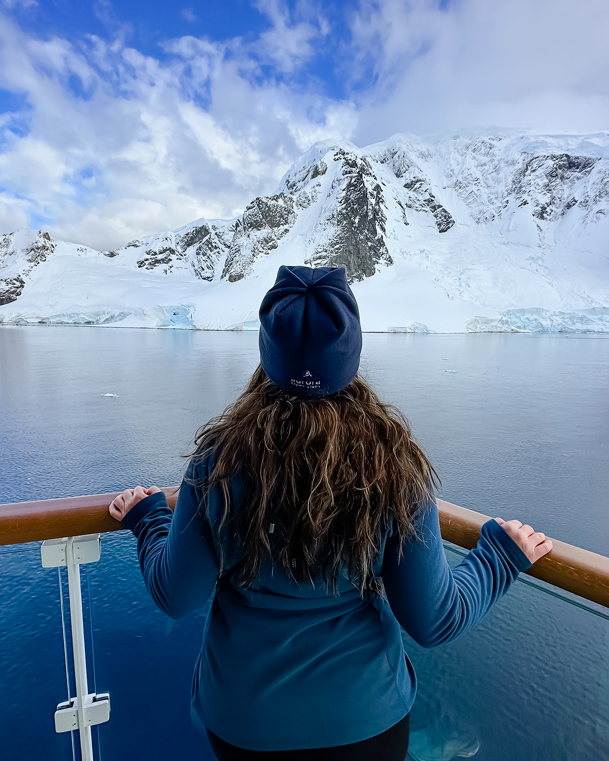 Woman looking at dramatic scenery from Greg Mortimer top deck